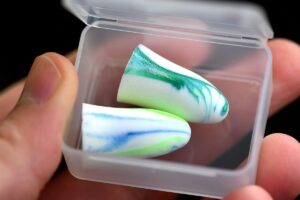 Deux bouchons d'oreilles colorés dans une petite boîte plastique