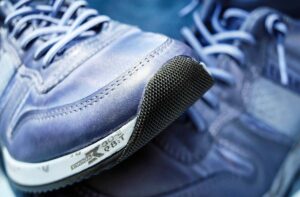 Des baskets bleues en cuir avec semelle noire et lacets blancs