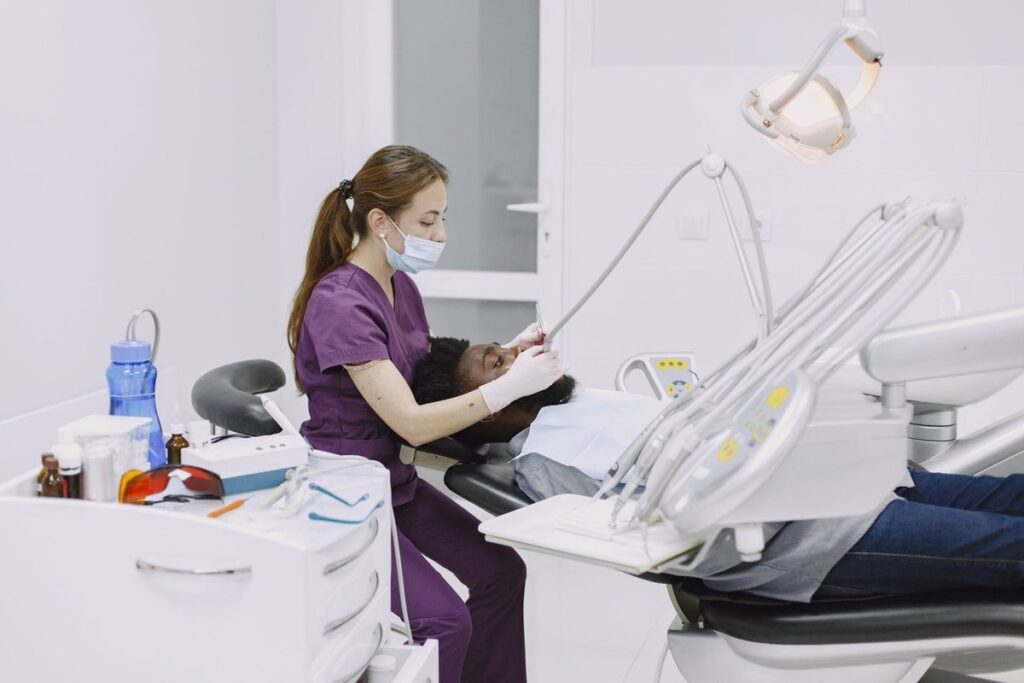 Professionnel de santé dentaire examinant un patient dans un cabinet