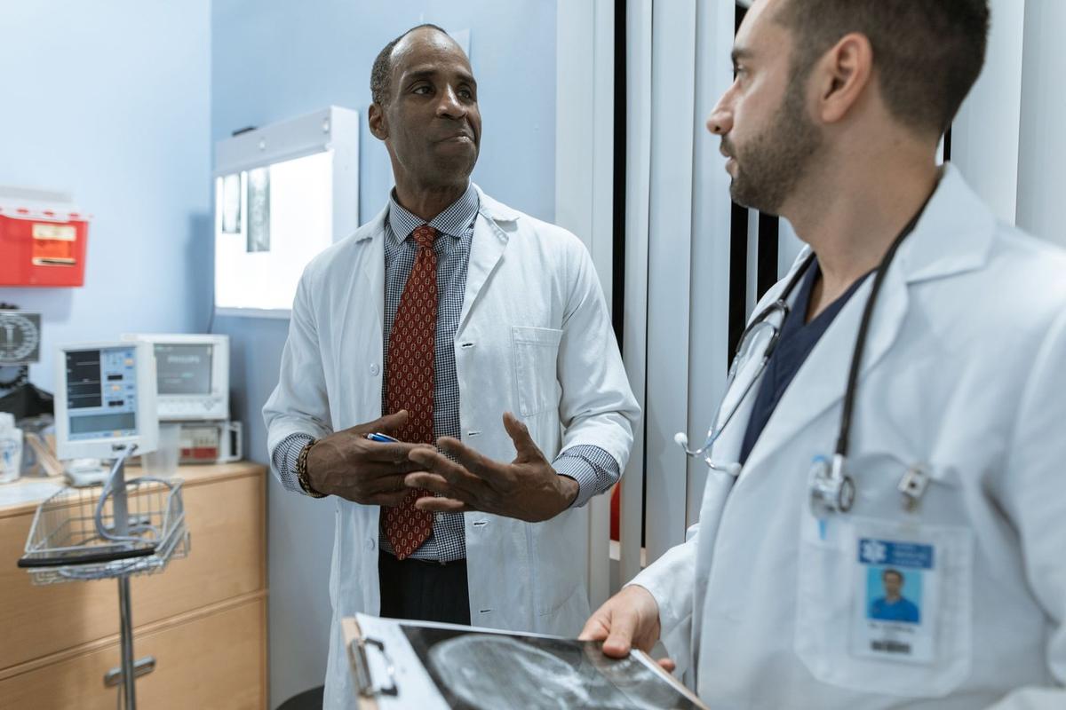 Deux médecins en conversation dans un cabinet médical, l'un tient une radiographie